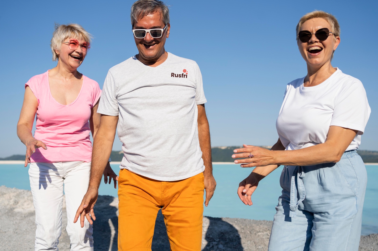 Tre venner ler sammen ved en strand
